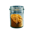 Clear glass jar filled with a yellow powder on a white background