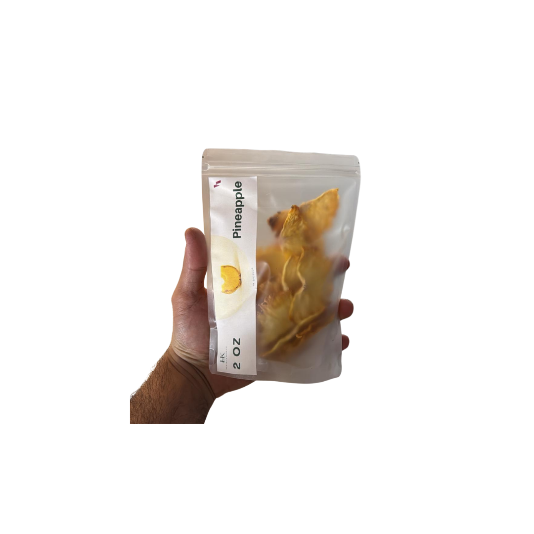 Hand holding a package of pineapple-flavored snack on a white background