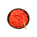 Red spice in a black bowl with a wooden spoon on a white background
